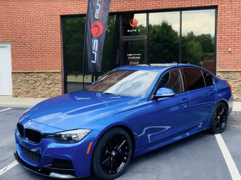 A blue bmw parked in front of a building.